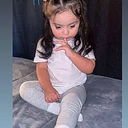 Amelia joined the competition — help win amazing prizes! blanket, cartoon, child, curtains, cute, entertainment, finger_on_lips, focused, girl, gray_pants, home, indoor, long_hair, pink_bows, playing, sitting, smartphone, toddler, white_shirt, white_socks