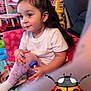 Amelia is registered to the contest to win money with this photo: child, colorful, cute, furniture, hair_accessory, happy, indoor, ladybug_emoji, person, play_mat, playroom, purple_leggings, sitting, small_object, smiling, sock, toddler, toy_shelves, white_bow, young_child