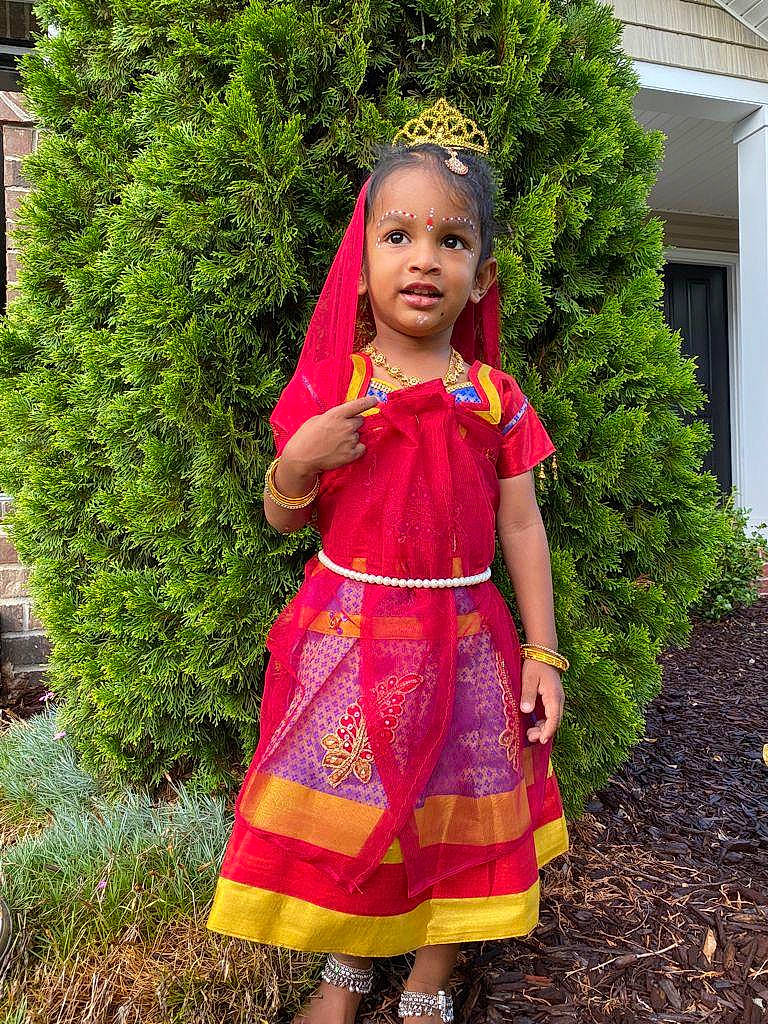 Nethran is registered to the contest to win money with this photo: baby_toddler_clothing, botany, day_dress, dress, event, fashion_design, grass, happy, head, leaf, magenta, one_piece_garment, outerwear, people_in_nature, person, pink, plant, purple, shrub, toddler