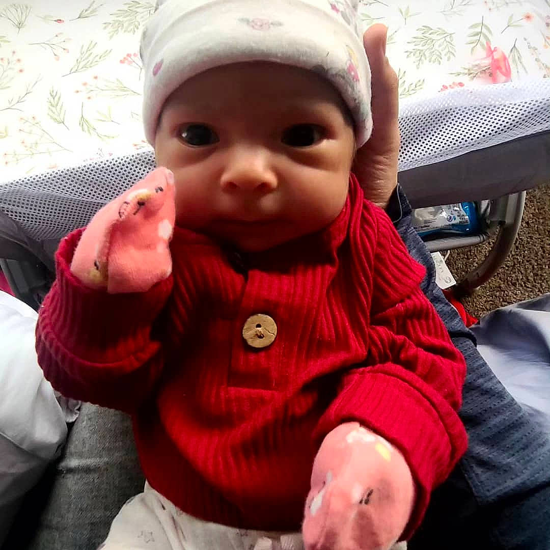 Audrey is registered to the contest to win money with this photo: baby, baby_toddler_clothing, cap, cheek, eye, eyelash, face, finger, hand, happy, headwear, lip, mouth, nose, person, pink, seat_belt, skin, sleeve, thumb