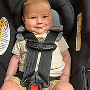 Easton is registered to the contest to win money with this photo: baby, car_seat, child, smile, straps, infant, cute, safety, seat_belt, happy, toddler, clothing, shorts, light_skin, indoors, person, head_support, seat, closeup, young_child