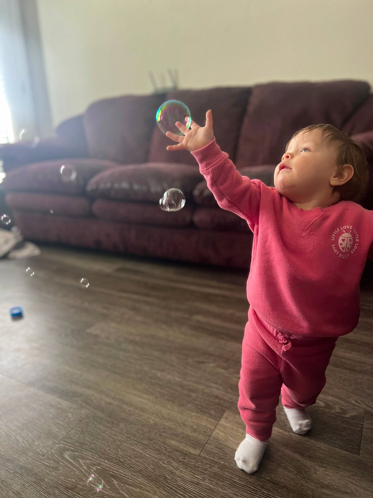 Davina is registered to the contest to win money with this photo: baby, baby_toddler_clothing, child, comfort, finger, floor, flooring, fun, gesture, happy, hardwood, head, human_body, joint, laminate_flooring, leg, person, sitting, sleeve, toddler