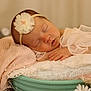 baby, newborn, sleeping, headband, flower_headband, blanket, pillow, lace, hand, mouth, rosy_cheeks, basket, soft_texture, pastel, props, portrait, closeup, peaceful, cozy, studio_photography