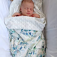 Tabitha joined the competition — help win amazing prizes! newborn, baby, sleeping, blanket, floral_pattern, crib, plush_toy, teddy_bear, soft_texture, white, blue, green, peaceful, infant, wrapped, cozy, comfortable, portrait, indoors, resting