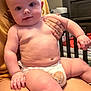 Grayson is registered to the contest to win money with this photo: baby, infant, diaper, child, person, skin, hand, face, legs, sitting, indoor, furniture, cradle, cute, plump, curious, expression, holding, comfort, room
