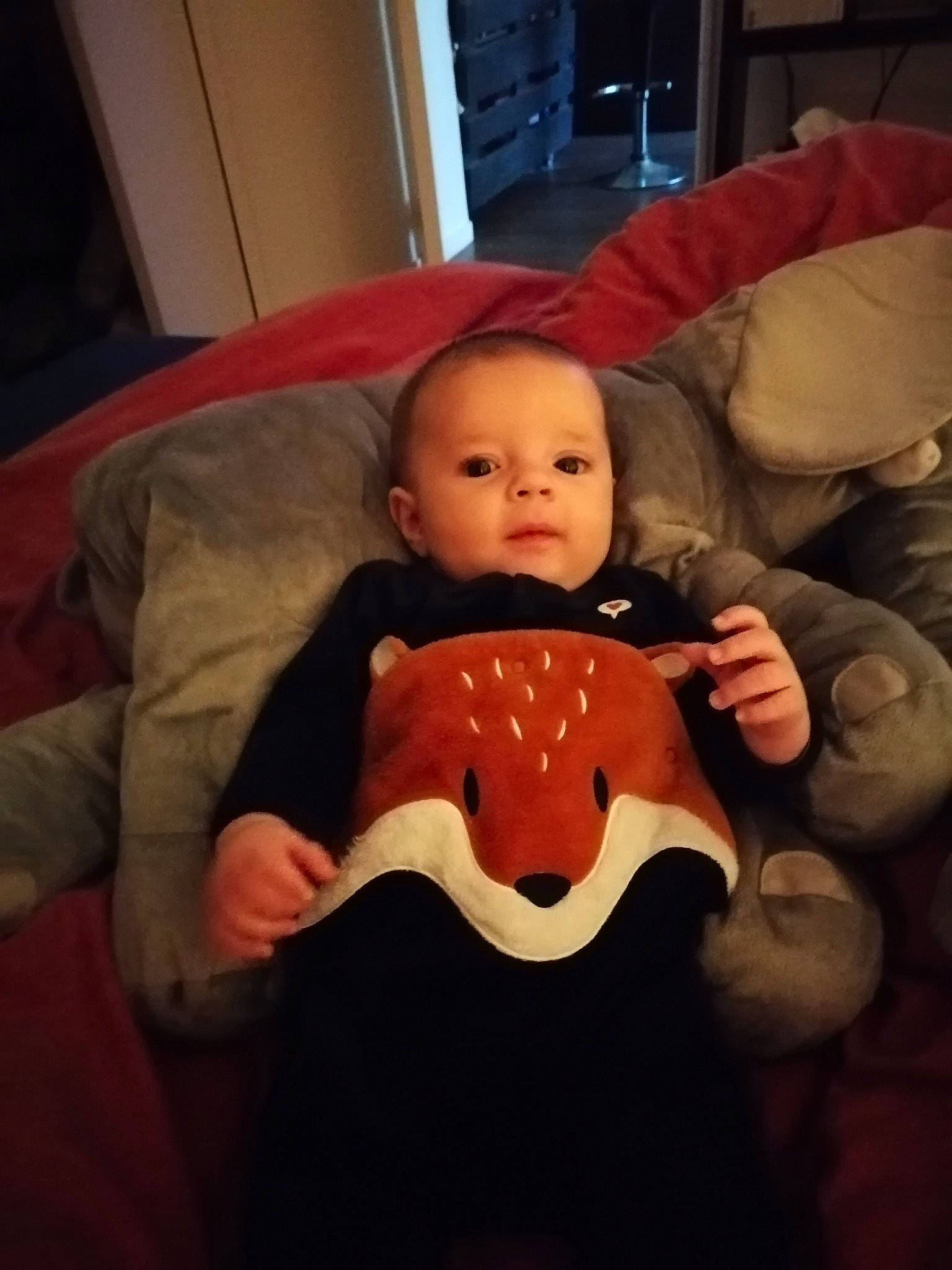 Soann a rejoint le concours — aidez-le/la à gagner de superbes lots ! baby, baby_toddler_clothing, carmine, cheek, child, comfort, eye, flooring, fun, human_body, lap, linens, mouth, person, room, sitting, sleeve, stuffed_toy, t_shirt, toddler