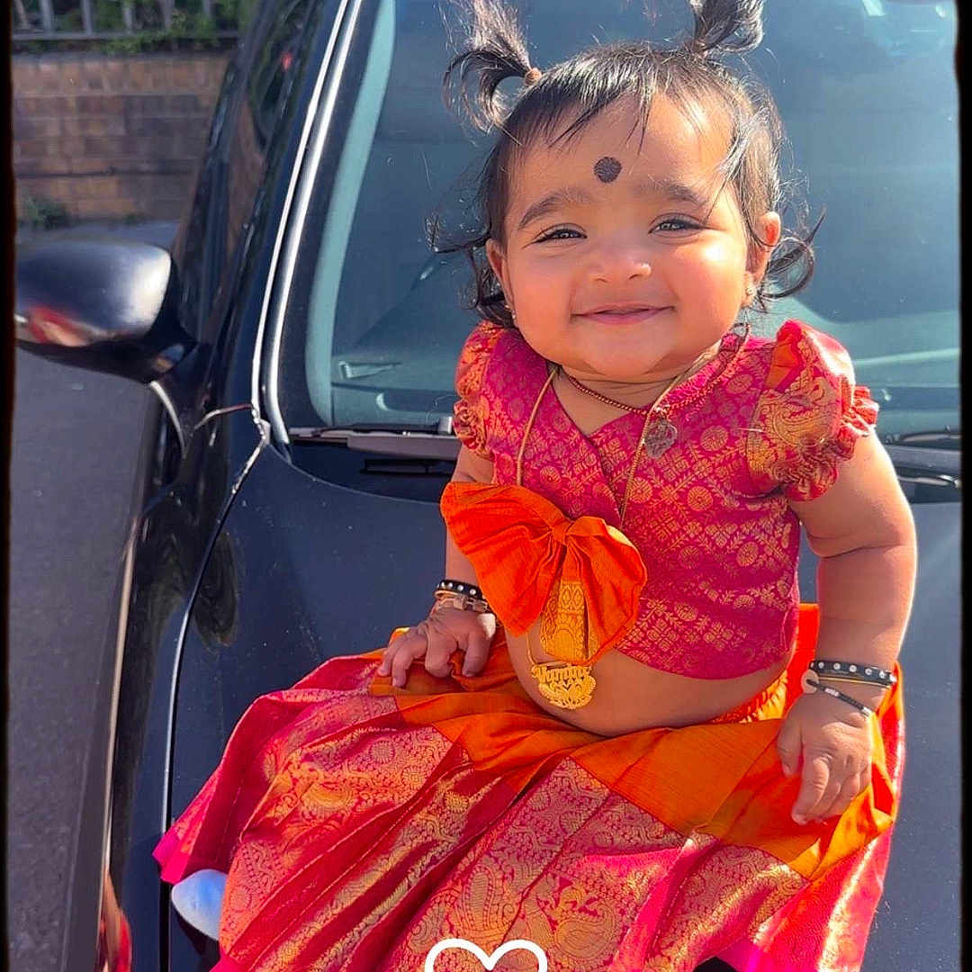 Vamini is registered to the contest to win money with this photo: accessories, car, child, clothing, dress, face, female, girl, happy, head, person, photography, portrait, purple, sedan, sitting, skirt, smile, transportation, vehicle