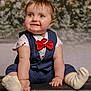 baby, background_blur, blue_vest, child, chubby_cheeks, cute, festive, happy, holiday_theme, indoor, infant, leather_surface, portrait, red_bow_tie, short_hair, sitting, smiling, snow_effect, socks, white_shirt