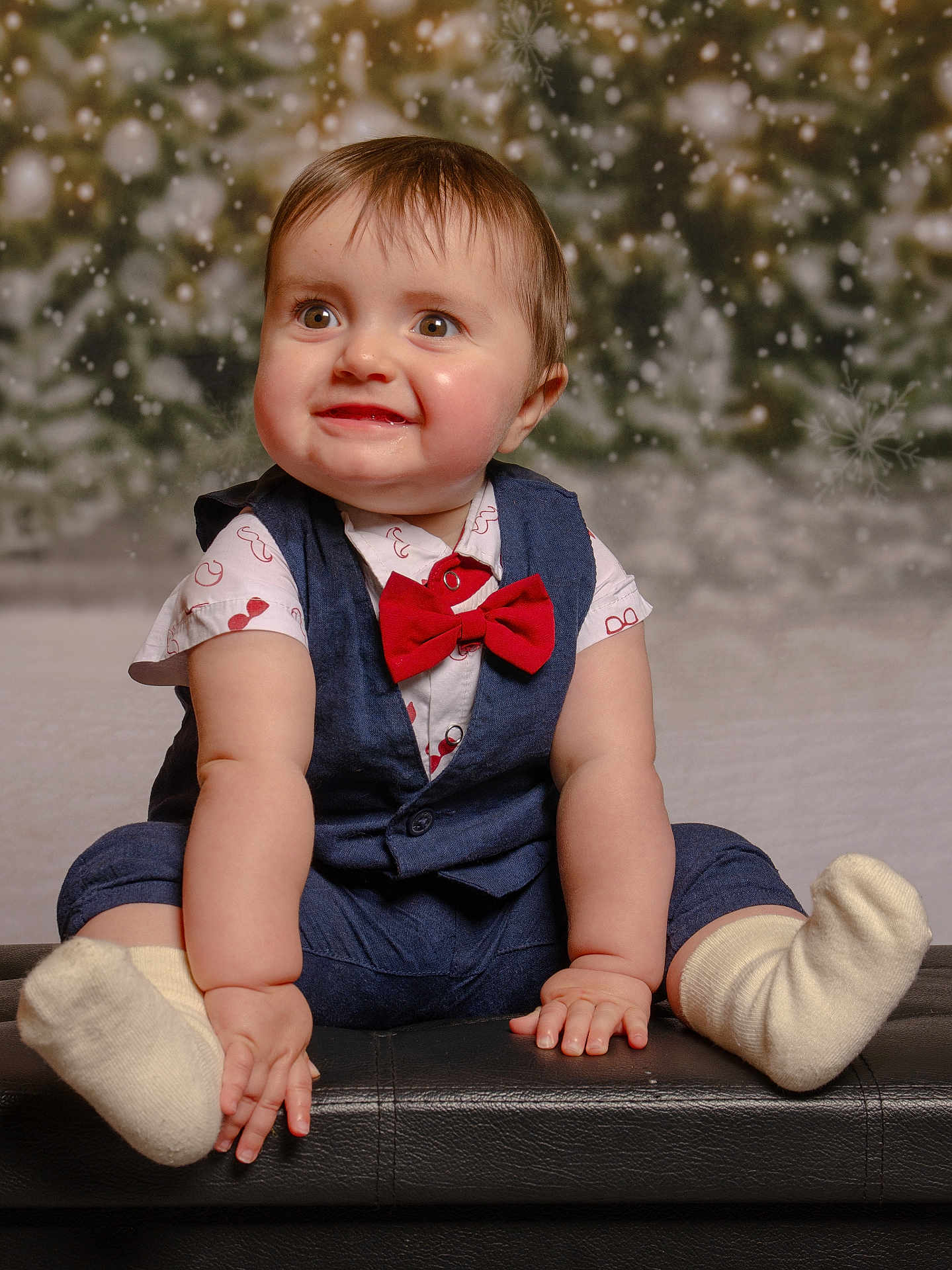 Colin a rejoint le concours — aidez-le/la à gagner de superbes lots ! baby, background_blur, blue_vest, child, chubby_cheeks, cute, festive, happy, holiday_theme, indoor, infant, leather_surface, portrait, red_bow_tie, short_hair, sitting, smiling, snow_effect, socks, white_shirt