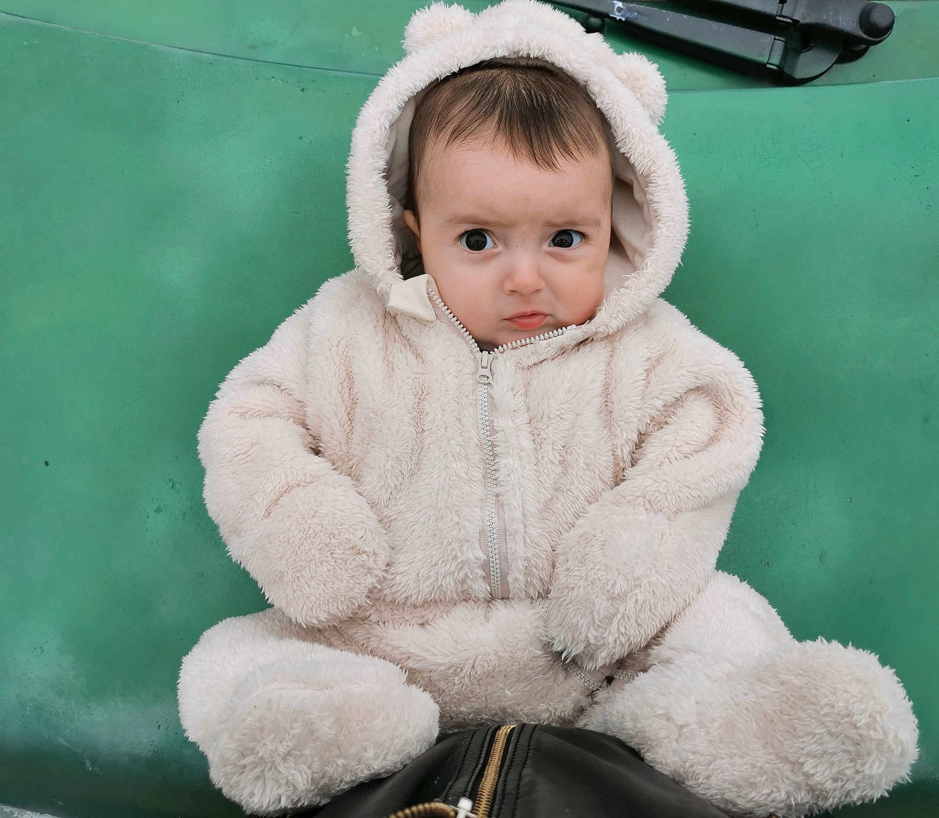 Colin participe au concours pour gagner de l'argent avec cette photo : baby, child, fur_suit, hood, green_background, cute, expression, sitting, portrait, winter_clothing, zipper, face, eyes, hands, feet, infant, warm, cozy, one_person, indoors