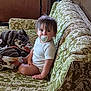 Rileigh is registered to the contest to win money with this photo: toddler, child, pacifier, couch, blanket, indoors, vintage_furniture, green_pattern, wooden_wall, curly_hair, sitting, portrait, cozy, home_interior, casual_clothing, baby, furniture, comfort, looking_at_camera, relaxed