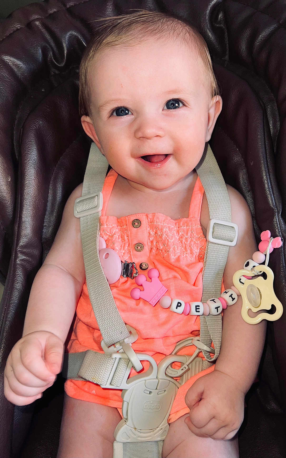 Nathanaelle participe au concours pour gagner de l'argent avec cette photo : baby, child, car_seat, smiling, blue_eyes, pacifier, pacifier_clip, pink, coral_outfit, straps, harness, cute, infant, happy, portrait, indoors, skin, hand, face, person
