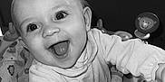 Nathanaelle a rejoint le concours — aidez-le/la à gagner de superbes lots ! baby, infant, smiling, happy, face, eyes, mouth, tongue, hand, clothing, toy, baby_seat, pattern, indoor, child, person, monochrome, black_and_white, cute, joyful