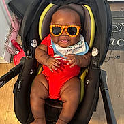 Kairo joined the competition — help win amazing prizes! baby, child, sunglasses, red_onesie, car_seat, indoor, floor, mop, dustpan, happy, smiling, cute, infant, legs, feet, hands, bib, black_car_seat, wood_floor, playful