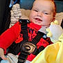 baby, car_seat, child, clothing, comfort, cute, face, happy, harness, indoors, infant, person, plush_toy, portrait, red_hair, red_shirt, seatbelt, smiling, soft_toy, yellow_blanket