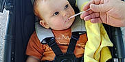 Scott joined the competition — help win amazing prizes! baby, black_stroller, blanket, child, childcare, curious_expression, cute, daylight, feeding, feeding_time, hand, infant, orange_clothing, outdoor, portrait, seatbelt, sitting, spoon, stroller, yellow_blanket