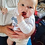 baby, child, infant, person, hand, clothing, socks, whale, indoor, adult, holding, cute, curious, face, finger, long_sleeve, pants, seated, carpet, cozy