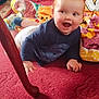 baby, blanket, carpet, child, clothing, colorful, crawling, cute, floor, happy, home, indoor, long_sleeve_shirt, person, playful, red_hair, smiling, toddler, wooden_table_leg, young_child