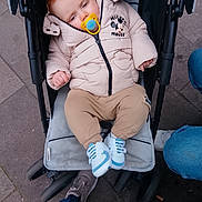 Scott joined the competition — help win amazing prizes! baby, child, stroller, pacifier, jacket, mickey_mouse, footwear, pavement, urban, person, clothing, casual, winter, outdoor, cute, infant, sitting, hooded, shoes, legs