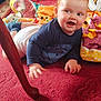 baby, blanket, cheeks, child, colorful, crawling, curious, floor, footwear, hand, happy, indoor, infant, navy_blue_shirt, person, play, portrait, red_carpet, smile, wooden_chair_leg