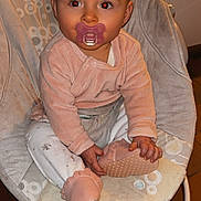 Kym a rejoint le concours — aidez-le/la à gagner de superbes lots ! baby, pacifier, bouncer, pink_clothing, white_pants, baby_shoes, indoor, red_eye, cute, child, infant, seat, floor_tiles, cozy, curious, hands, face, head, sitting, portrait