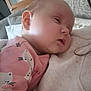 baby, sleeping, pink_clothing, animal_print, indoor, blanket, cozy, person, head, face, child, soft_texture, couch, closeup, peaceful, resting, infant, cute, warm, comfort