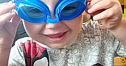 Jaxon joined the competition — help win amazing prizes! child, goggles, blue_goggles, smiling, indoor, spiderman_shirt, tshirt, hands, blond_hair, face, person, playful, furniture, chair, basketball, home, young_child, cute, happy, portrait