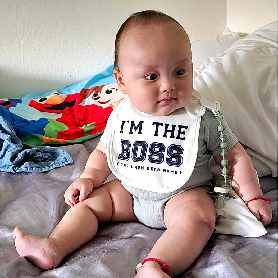 Felix Yang joined the competition — help win amazing prizes! baby, bed, bib, blanket, child, chubby, clothing, colorful, cute, expression, head, indoors, infant, person, playful, sitting, skin, smile, toy, young