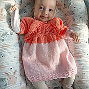 Maddie participe au concours pour gagner de l'argent avec cette photo : baby, infant, smile, blue_eyes, knitted_dress, pink, orange, tights, cushion, patterned, bunny_print, owl_print, soft_lighting, indoor, cute, child, portrait, lying_down, happy, cozy