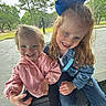 child, children, smiling, laughing, outdoor, park, bench, grass, trees, blue_bow, denim_jacket, pink_shirt, happy, playful, friends, sitting, casual_clothing, young_kids, nature, daylight