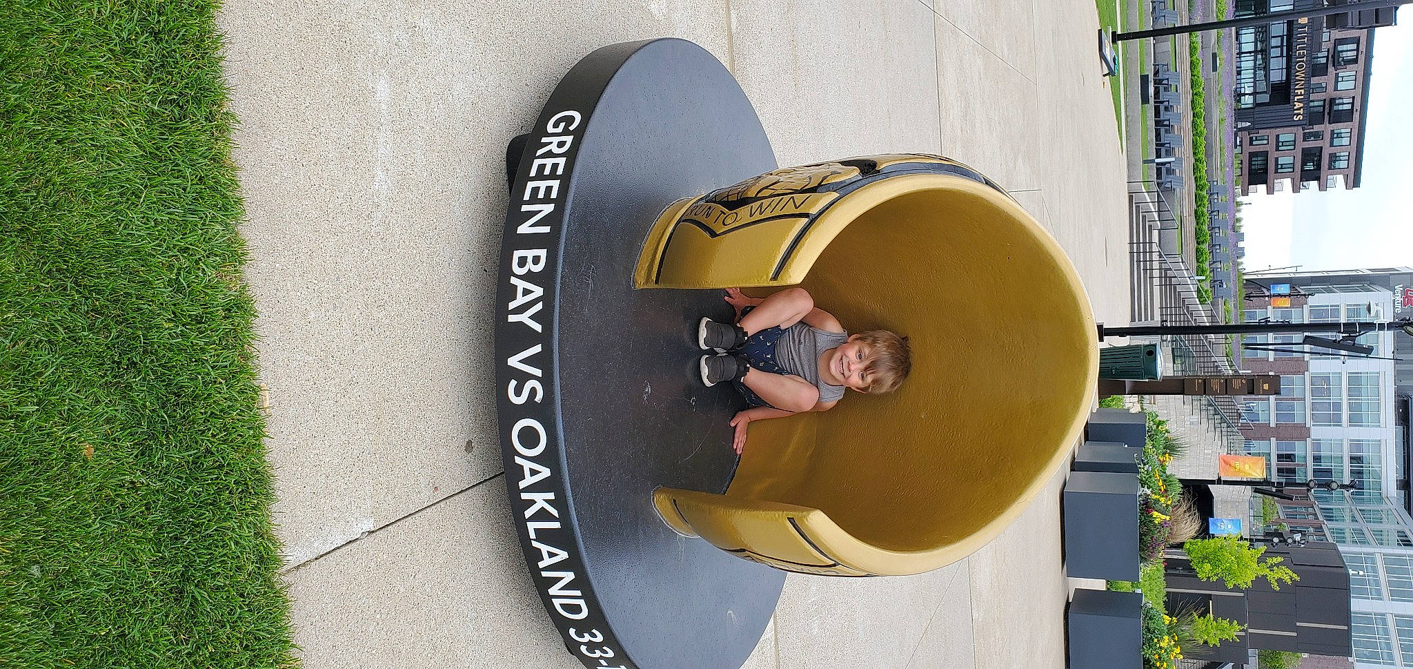 Harry is registered to the contest to win money with this photo: audio_equipment, automotive_wheel_system, circle, fashion_accessory, font, fun, grass, hat, headgear, joy, leisure, metal, musical_instrument, person, plant, recreation, sign, signage, smile, sun_hat