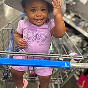 Sahara Jean is registered to the contest to win money with this photo: toddler, child, shopping_cart, hat, smile, purple_clothing, sneakers, indoor, store, person, cute, baby, retail, fun, happy, fashion, casual, portrait, shopping, toy