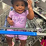 toddler, child, shopping_cart, hat, smile, purple_clothing, sneakers, indoor, store, person, cute, baby, retail, fun, happy, fashion, casual, portrait, shopping, toy