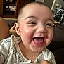 David is registered to the contest to win money with this photo: baby, smiling, happy, face, tongue, clothing, indoor, person, child, couch, hand, home, furniture, infant, cute, joyful, portrait, sitting, skin, head