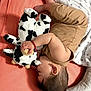Phoebe is registered to the contest to win money with this photo: baby, sleeping, plush_toy, cow_toy, bed, blanket, infant, soft_toy, child, furniture, peaceful, cute, resting, pink_sheet, brown_clothing, hand, foot, head, hair, ear