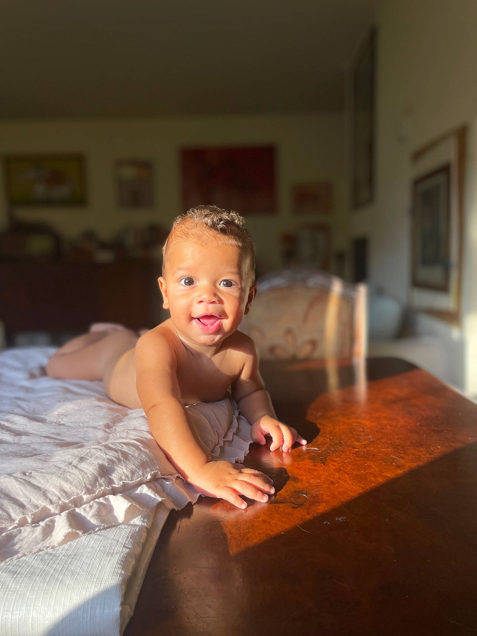 Carmelo is registered to the contest to win money with this photo: baby, bathing, bed, child, event, flash_photography, flooring, fun, happy, hardwood, linens, person, picture_frame, pillow, room, sitting, smile, table, toddler, wood