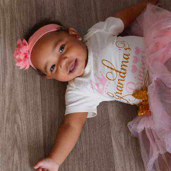 Treuleigh is registered to the contest to win money with this photo: accessories, baby, baseballcap, bodypart, bonnet, cap, clothing, costume, dress, face, finger, hand, hat, head, newborn, person, photography, portrait, t_shirt, wood