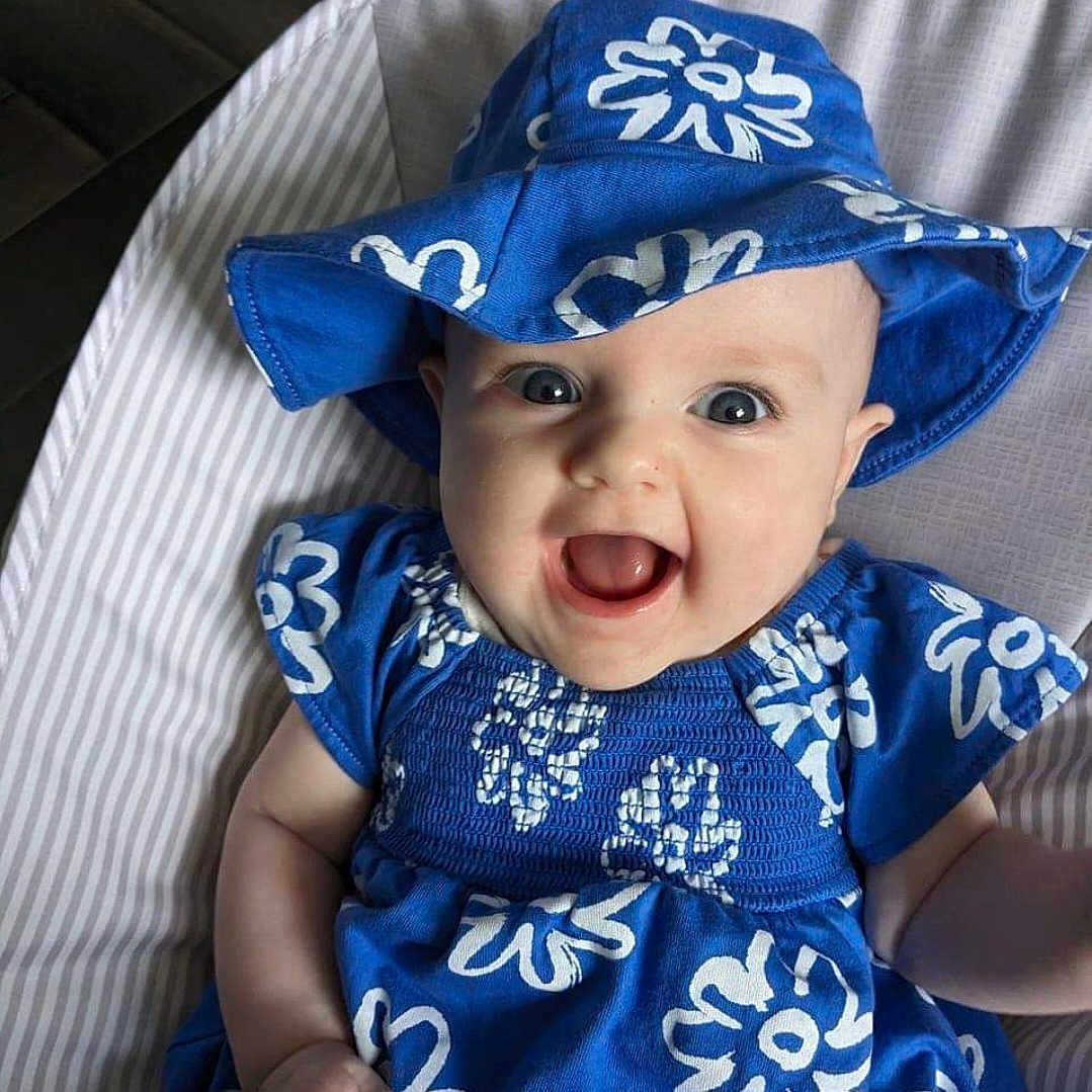 Blossom is registered to the contest to win money with this photo: accessories, baby, babylaughing, bonnet, cap, clothing, coat, costume, dress, face, happy, hat, head, jewelry, laughing, necklace, person, photography, portrait, sunhat