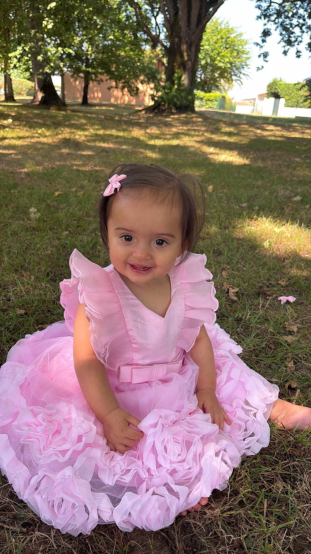 Ginger participe au concours pour gagner de l'argent avec cette photo : baby, bow, child, cute, daylight, grass, happy, nature, outdoor, park, pink_dress, playful, portrait, shade, sitting, smiling, sunlight, toddler, trees, young_child