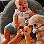 Emilio participe au concours pour gagner de l'argent avec cette photo : baby, smiling, child, plush_toy, cushion, white_shirt, shorts, indoor, happy, cute, sitting, toy, soft_toy, face, infant, feet, hand, comfort, person, portrait