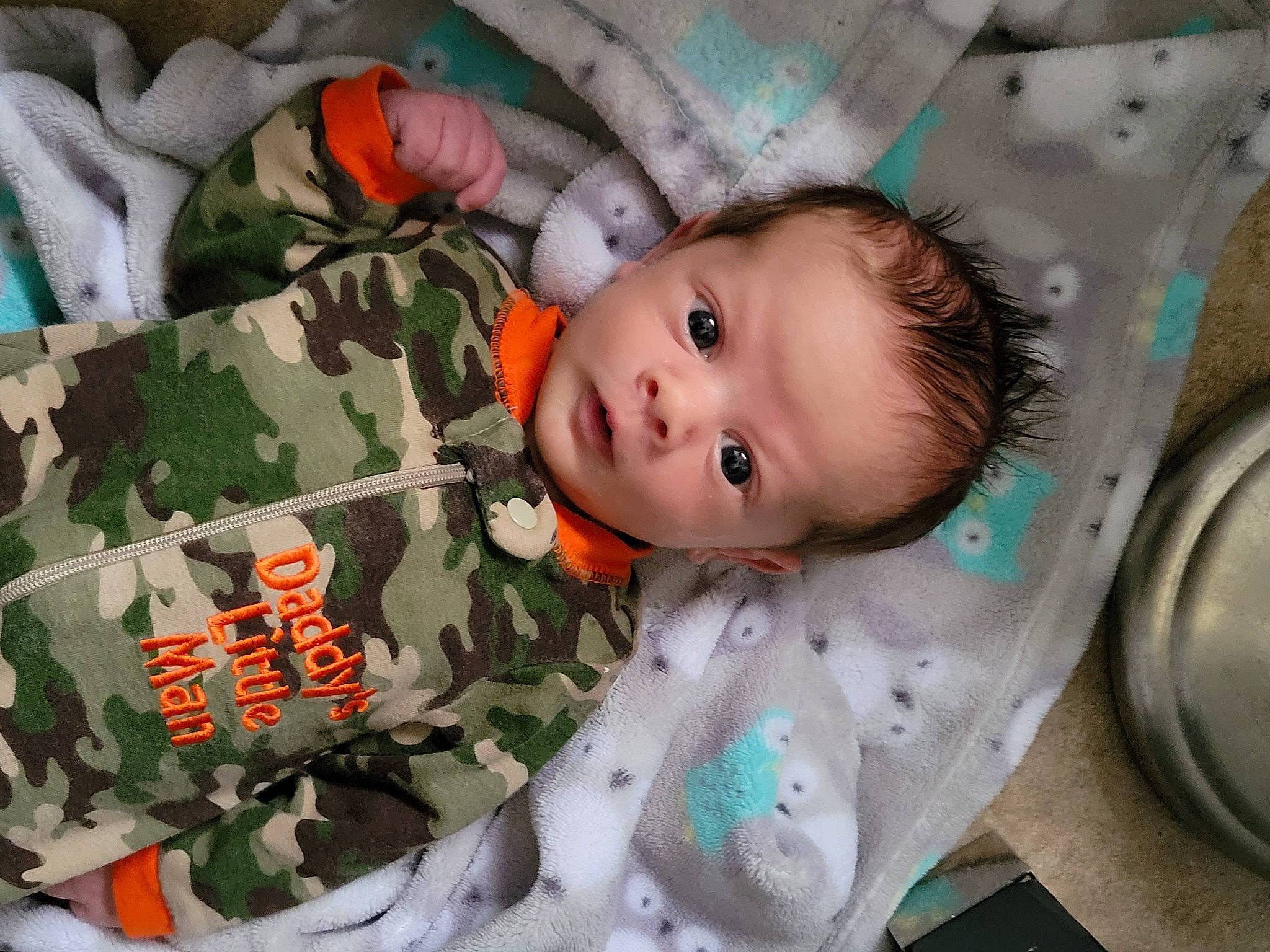 Colter is registered to the contest to win money with this photo: baby, baby_products, baby_safety, baby_toddler_clothing, camouflage, child, comfort, eye, face, iris, linens, mammal, military_camouflage, military_uniform, pattern, person, room, sleeve, textile, toddler