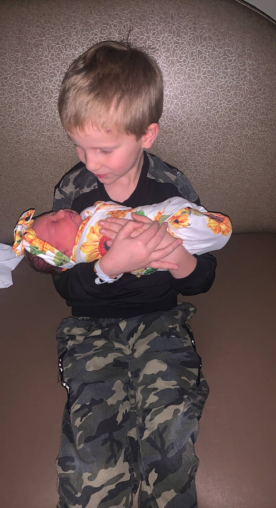 Cayden joined the competition — help win amazing prizes! baby, camouflage, child, elbow, event, finger, fun, gesture, happy, head, headwear, human_body, joint, musical_instrument, person, sharing, sitting, t_shirt, thigh, toddler