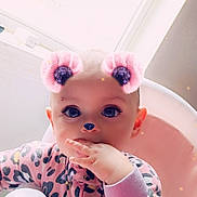 Aurora is registered to the contest to win money with this photo: baby, infant, child, face_filter, pink, highchair, leopard_print, onesie, hand_in_mouth, big_eyes, sparkles, bear_ears, glitter_nose, window, indoor, portrait, seat, cute, soft_lighting, closeup