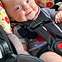 baby, child, car_seat, smile, blue_eyes, polka_dot_clothing, seatbelt, infant, safety, cute, happy, face, closeup, indoor, colorful, patterned, fabric, person, portrait, baby_clothes
