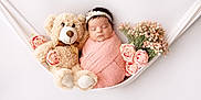 Aliyana is registered to the contest to win money with this photo: adorable, baby, child, cute, decorative, floral, flowers, hammock, headband, infant, newborn, peaceful, pink_blanket, portrait, resting, sleeping, soft, teddy_bear, toy, wrapped