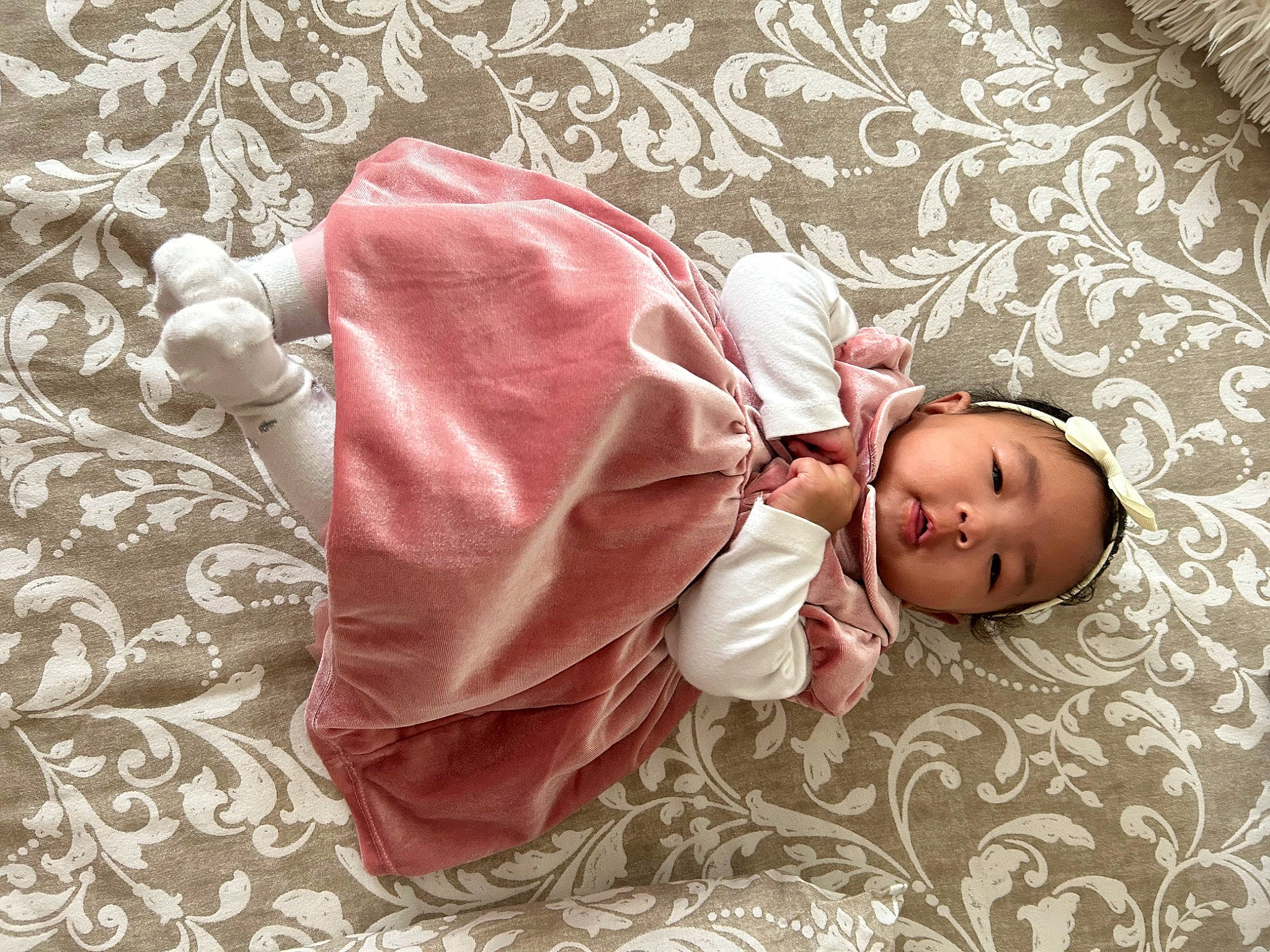 Mya participe au concours pour gagner de l'argent avec cette photo : baby, baby_products, baby_sleeping, baby_toddler_clothing, bedding, child, comfort, fashion_accessory, flooring, linens, magenta, pattern, peach, person, pink, room, sitting, sleeve, textile, toddler