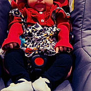 Edilia joined the competition — help win amazing prizes! baby, child, car_seat, red_clothing, headband, leopard_print, white_shoes, black_pants, infant, cute, smile, sitting, indoors, clothing, person, baby_accessories, seatbelt, face, young_child, portrait