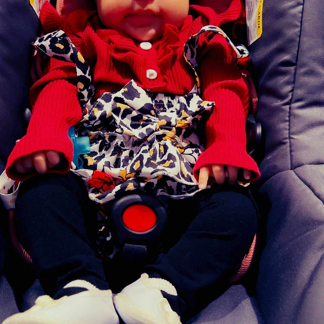 Edilia joined the competition — help win amazing prizes! baby, baby_accessories, black_pants, car_seat, child, clothing, cute, face, headband, indoors, infant, leopard_print, person, portrait, red_clothing, seatbelt, sitting, smile, white_shoes, young_child