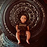 Bodie joined the competition — help win amazing prizes! baby, tire, wheel, black_rhino, infant, camo_onesie, face, feet, sitting, curious_expression, metal, rubber, indoor, portrait, closeup, child, automotive, dark_background, round, person