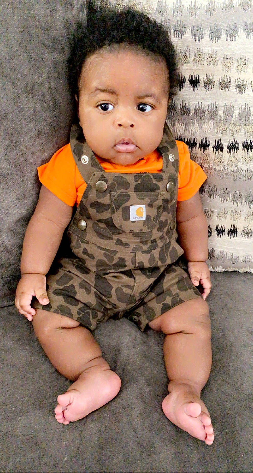 Kash is registered to the contest to win money with this photo: arm, baby_toddler_clothing, cheek, collar, eye, face, facial_expression, hand, happy, head, human, nose, organ, pattern, person, skin, sleeve, standing, t_shirt, thigh